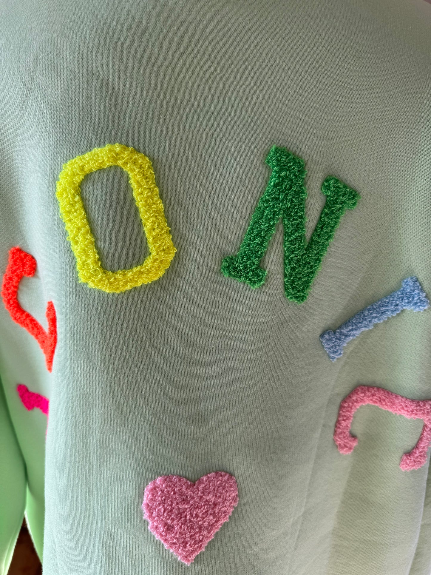 Sweatshirt in mintgrün, Schriftzug hinten in bunt